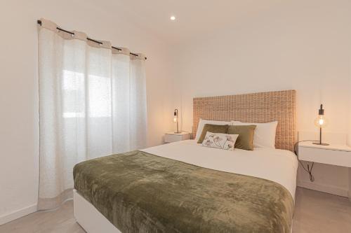 塞辛布拉Casa Pinhão的白色的卧室设有一张大床和一个窗户