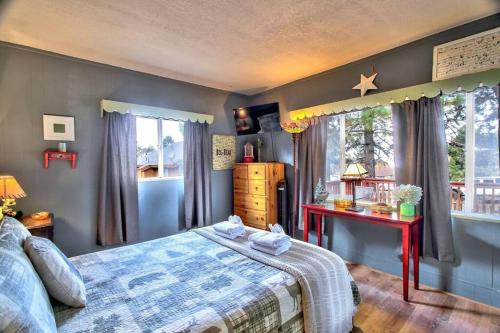 大熊湖Los Osos w/ Privarte Spa and BBQ的一间卧室配有一张床、一张桌子和一个窗户。