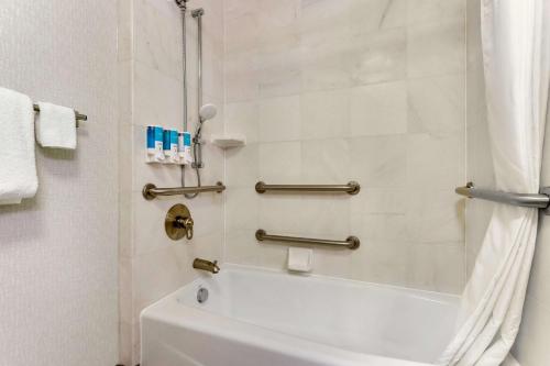 塞克斯顿塞克斯顿德鲁套房酒店的浴室配有白色浴缸和淋浴。