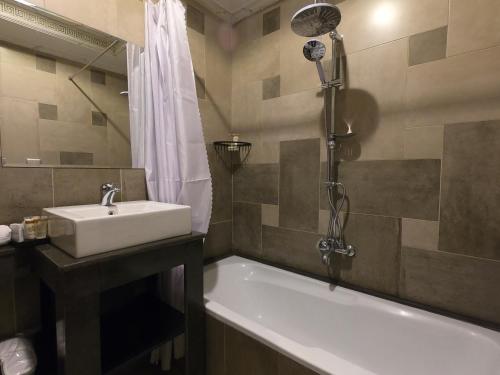 亚历山大Borg El Thaghr Hotel的浴室配有水槽、浴缸和淋浴