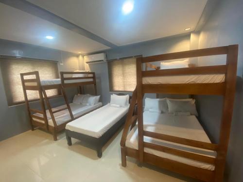 san juan la unionLakayo Hillside Apartelle的带三张双层床和一张床的房间