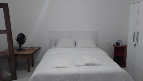 伊比科阿拉Residencial Maria de Lourdes的卧室配有白色的床和2条毛巾