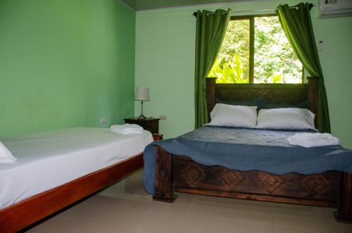 希门尼斯港Natural Harmony Cabin的一间卧室设有两张床和窗户。