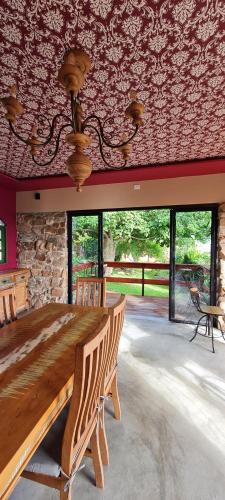 Serra de São BentoPousada Lajedo的一间设有木桌和石墙的用餐室