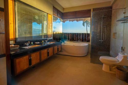 八打雁The Asri Dive and Leisure Resort的带浴缸、水槽和浴缸的浴室