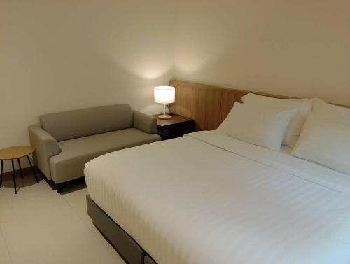 芭堤雅市中心芭堤雅西山酒店的一间卧室配有一张床、一把椅子和一盏灯