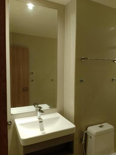 芭堤雅市中心芭堤雅西山酒店的一间带水槽、镜子和卫生间的浴室