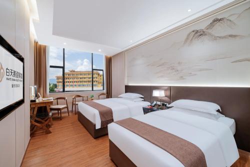 肇庆白天鹅迎宾馆的酒店客房配有两张床和一张书桌