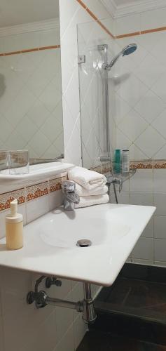蒂亚斯Apartamentos JANESKA的浴室设有白色水槽和镜子