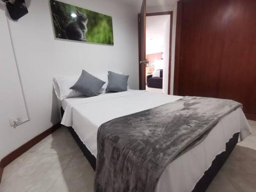 萨瓦内塔Acogedor Apto Parque Sabaneta的卧室配有一张白色大床