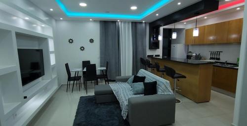 普拉亚Nha Maria Apartament的客厅以及带沙发和桌子的厨房。