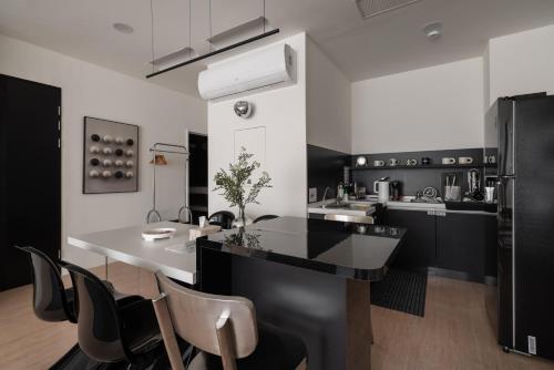 台南双层公寓 Duplex Apt.的厨房配有黑白台面和椅子
