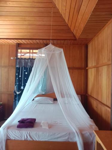 KododaLestari Cottages的一间卧室,配有一张带蚊帐的床