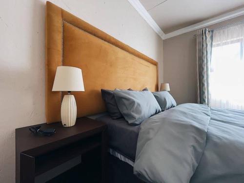 约翰内斯堡Sekgome Resort的一间卧室配有一张床和一张带台灯的桌子
