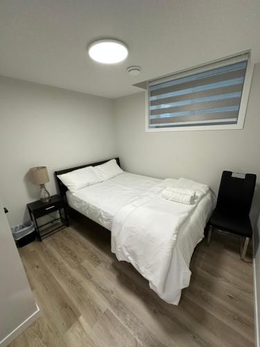卡尔加里2 Bedroom 2 Washrooms Brand New Beautiful & Cozy Suite的卧室配有白色的床和黑椅