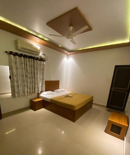 马尔万Tarkarli Resort Ganpat Prasad的客房设有一张床和一个吊扇。