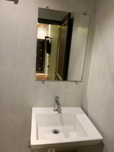 马尔万Tarkarli Resort Ganpat Prasad的浴室设有白色水槽和镜子