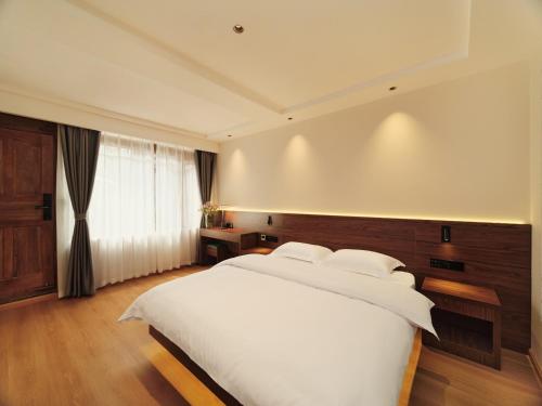 丽江丽江夕露小榭客栈的卧室设有一张白色大床和一扇窗户。