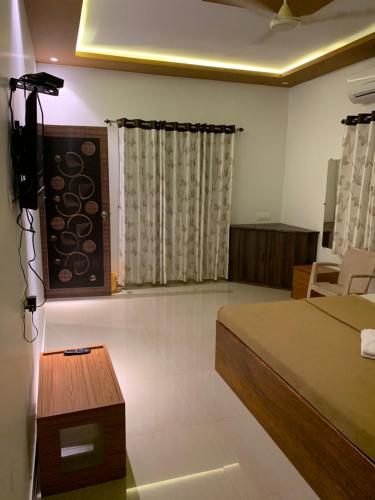 马尔万Tarkarli Resort Ganpat Prasad的卧室配有一张床和一张桌子
