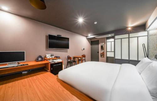 釜山Brown Dot Hotel Daeyeon的酒店客房,配有床和电视