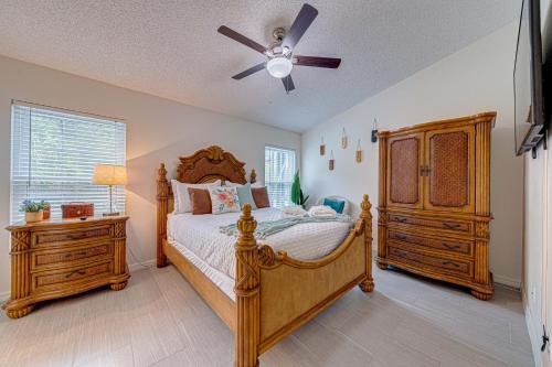 奥兰多Cozy Autumn Creek Retreat的一间卧室配有一张木床和吊扇