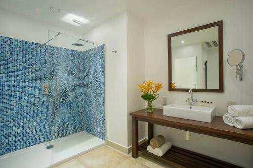 达累斯萨拉姆The Oyster Bay Hotel Suites的浴室配有盥洗盆和带镜子的淋浴