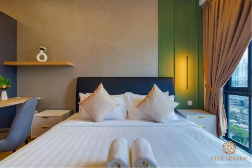 吉隆坡Sentral Suites Kuala Lumpur, Five Senses的一间卧室,配有一张带一双脚的床