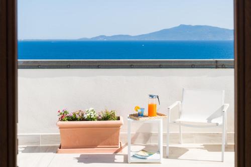 塔拉莫内特拉摩尼奥酒店的阳台配有桌椅,享有海景。
