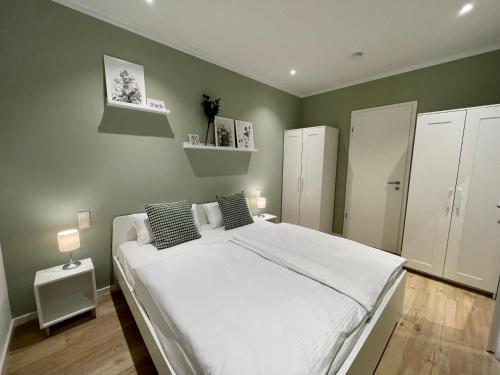 汉堡Condo Apartments Hamburg的卧室设有一张白色大床和绿色的墙壁