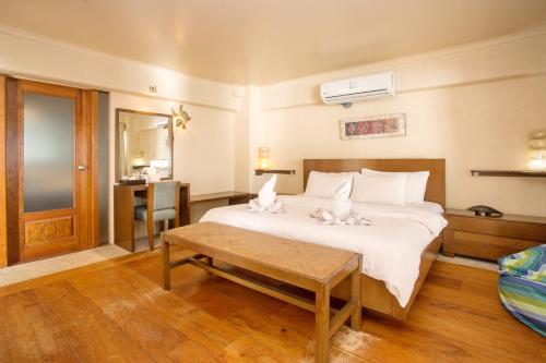 长滩岛Mayumi Beach Villa的一间卧室配有一张大床和一张桌子