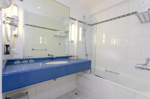 巴黎Hotel Etats Unis Opera的浴室设有蓝色水槽和镜子
