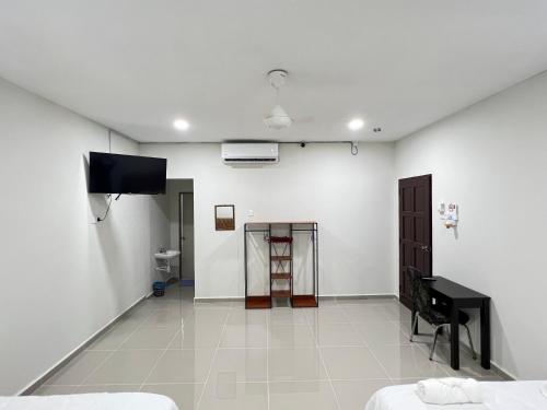 瓜拉丁加奴TAMU ROOMSTAY TOK MOLOR的一间白色的房间,配有电视和钢琴