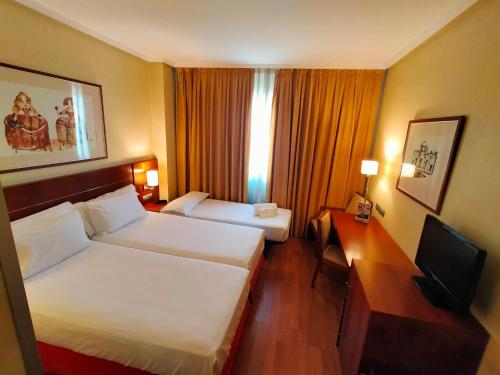 莫斯托雷斯Checkin La Princesa的酒店客房配有两张床和一张书桌