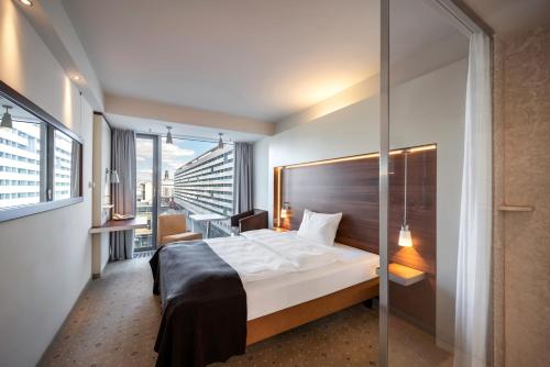 德累斯顿普尔曼·德瑞斯登·纽沃酒店的酒店客房设有一张床和一个阳台。