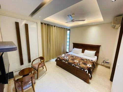 新德里Divine India Service Apartment 4Bhk D-163 Saket的卧室配有一张床和一张桌子及椅子