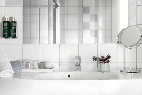 斯塔万格斯塔万格克丽奥酒店的白色瓷砖浴室设有水槽和镜子
