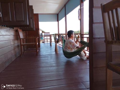 东德岛Namknong view的坐在一个房间里吊床上的人