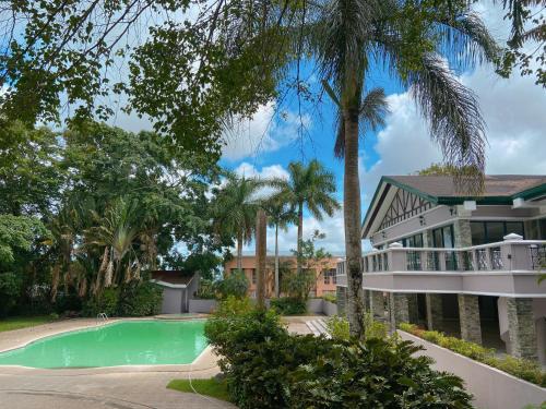 大雅台A nature’s den in Tagaytay的一座带游泳池和棕榈树的房子