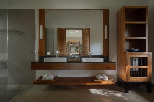 本托塔Kirana - A Santani Villa的一间带两个盥洗盆和大镜子的浴室