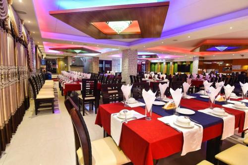 杰索尔Hotel Orion International的宴会厅配有红色和蓝色的桌椅