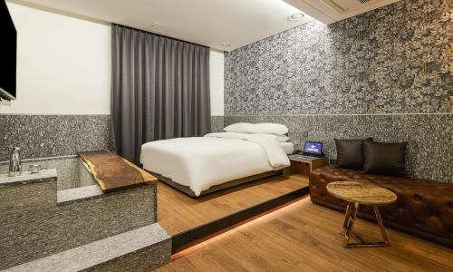 仁川市Incheon Guwol Hotel Bay 204的一间卧室配有一张床、一张桌子和一张沙发