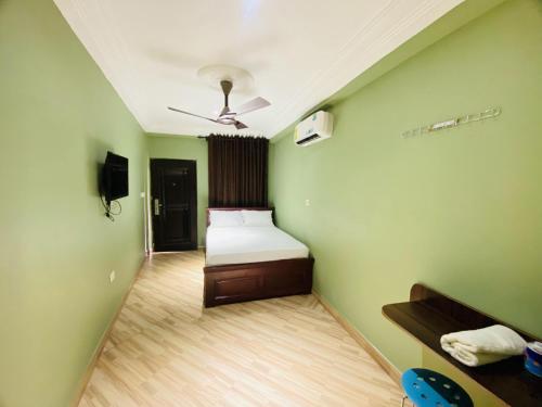 库马西Abanaba lodge& Restaurant的卧室设有一张位于绿色墙壁上的床铺