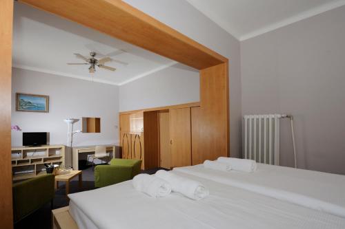 帕尔杜比采兹拉塔斯提卡酒店的一间卧室配有一张床,上面有两条毛巾