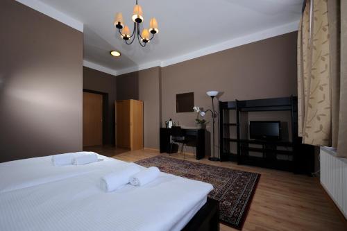 帕尔杜比采兹拉塔斯提卡酒店的卧室配有白色的床和壁炉