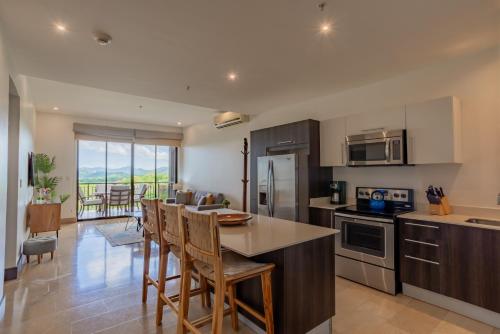 普拉卡海尔Roble Sabana 404 Luxury Apartment Adults Only - Reserva Conchal的一间厨房,里面配有桌椅