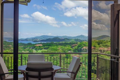 普拉卡海尔Roble Sabana 404 Luxury Apartment Adults Only - Reserva Conchal的山景阳台(带椅子)