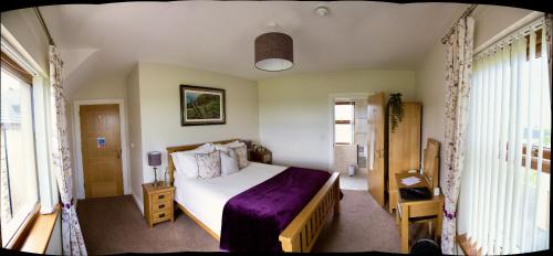 基尔基尔Mourne Country House Bed and Breakfast的一间卧室配有一张带紫色毯子的床