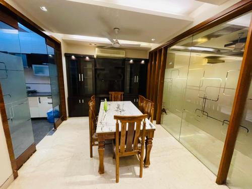 新德里Divine India Service Apartment 4Bhk D-163 Saket的一间设有桌子和玻璃墙的用餐室