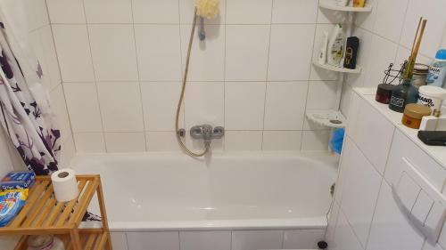 吕贝克Privatzimmer in St. Jürgen, gute Anbindung Zentral的浴室设有带淋浴头的白色浴缸。