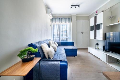 阿玛考德佩拉Beachfront apartment in Armação的客厅配有蓝色的沙发和桌子